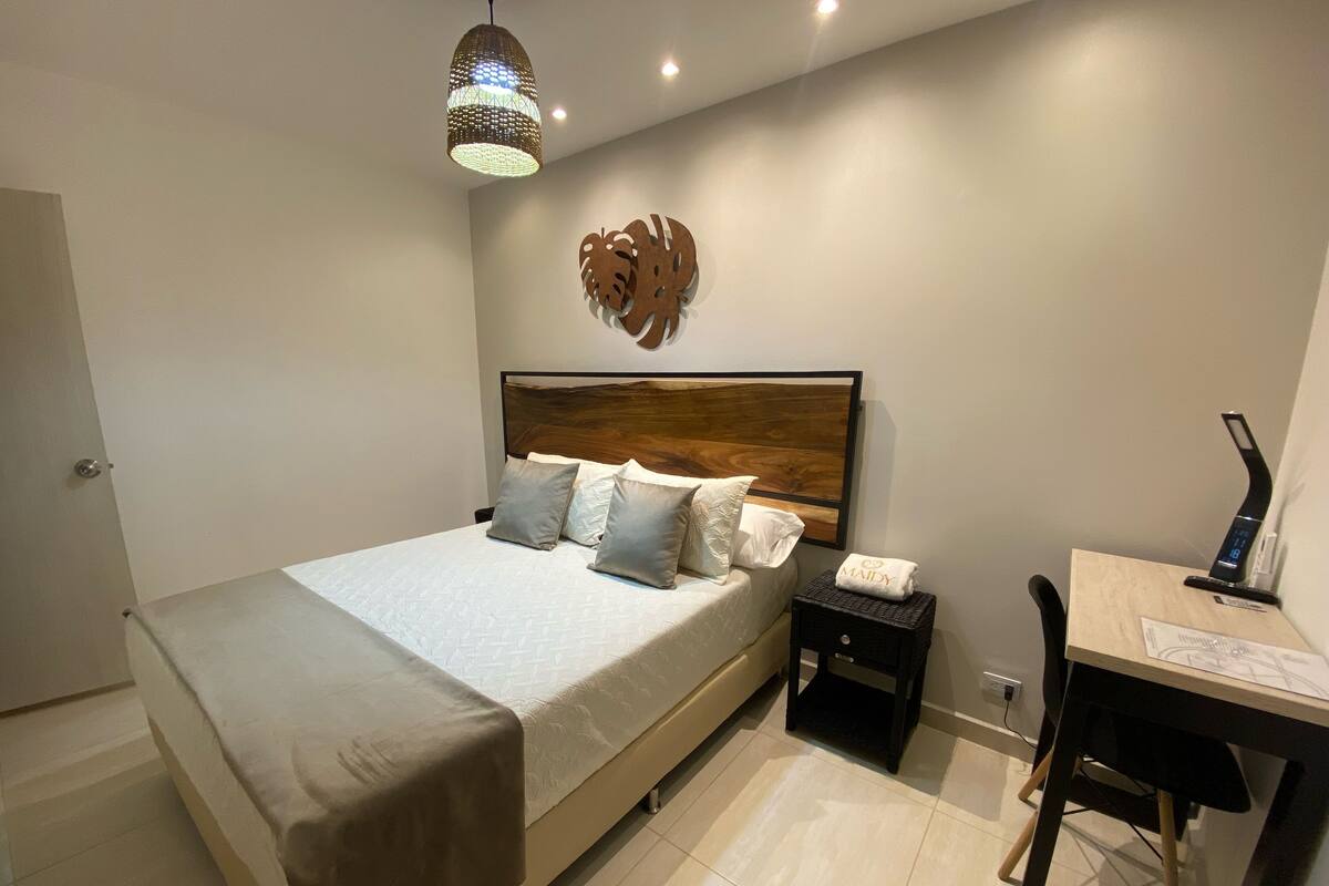 Une chambre à coucher comprenant un lit, une table de chevet, un bureau et un élément décoratif mural.
