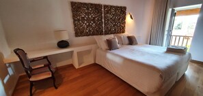 Un dormitorio con cama, escritorio y silla.