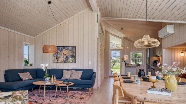 A spacious living area with a sofa, coffee table, and dining table.