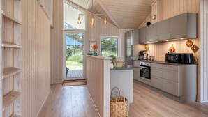 Een moderne keuken met houten keukenkastjes, een inbouwoven en een groot eiland met een spoelbak.