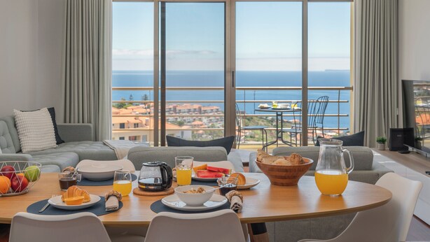 Ein Essbereich mit Frühstückstisch, einer Couch und Meerblick.