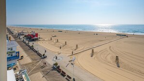 A beach with a boardwalk, beach chairs, and umbrellas. - 🏖️ Luxury Oceanfront Retreat • Steps to Boardwalk • Rooftop Pool + Parking 🏖️ (Ocean City)