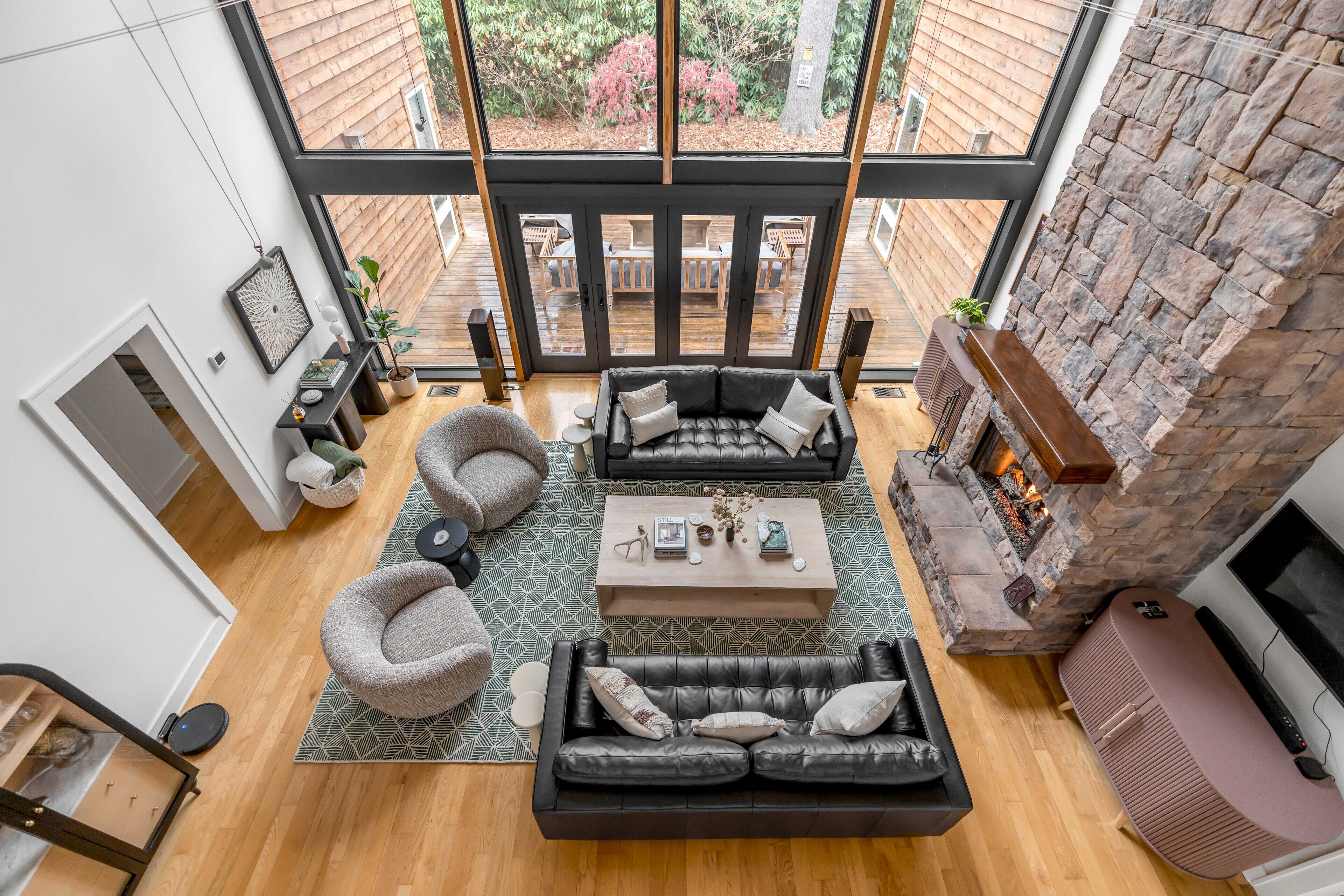 A spacious living area with a fireplace, two sofas, a coffee table, and a view of the outdoor deck.