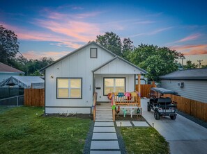 A single-story house with a front porch, a covered patio, and a small garden area.