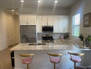 Enjoy cooking in this well-equipped kitchen with a refrigerator, oven, and microwave, and sit at the bar with three stools.