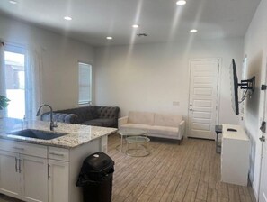 Cozy living space with a kitchen area, sofa, and TV.