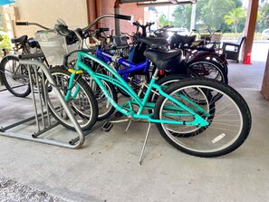A bicycle parking area with multiple bicycles, including a teal one with 'Next' on the seat. - Waterfront Resort Condo – Clearwater Beaches & Honeymoon Island, Sunset, Bikes (Dunedin)