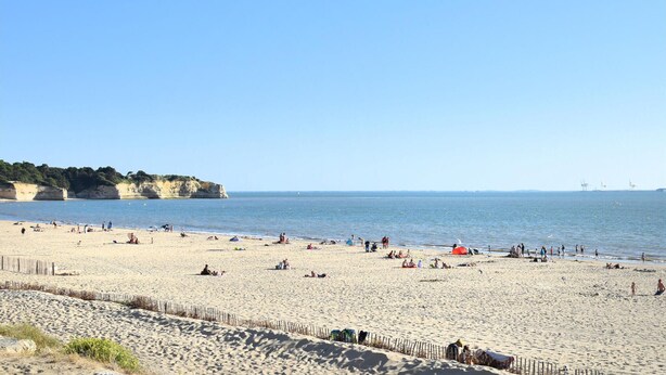 A wide sandy beach with people sunbathing and swimming, a wooden fence in the foreground, and cliffs in the background. - 2 bedroom gorgeous home in St-Georges-de-Didonn (St-Georges-de-Didonn)