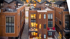 A modern multi-story residential building with a central courtyard, large windows, and outdoor seating areas. - Downtown WP Loft 21 I Rooftop Hot Tub & Lounge I Great Views I Bunks I Discounted Attractions (Winter Park)