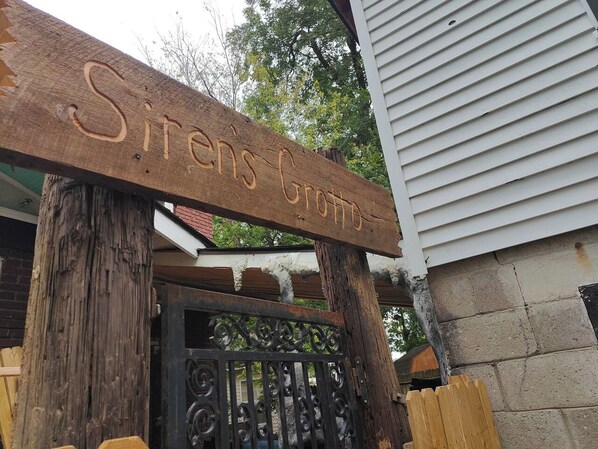 A wooden sign with the inscription "Sirens Crossing" mounted on a post. - Pirate Seeking crew. Downtown with hot tub! (fort smith)