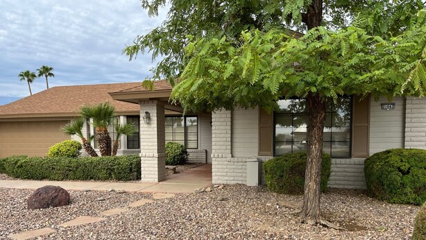 A building with a covered patio, stone steps, and a gravel driveway. - Your Private 19th Hole With Golf Cart Included In Rental (Sun City West)