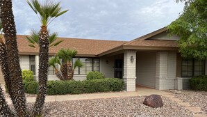 A building with a tiled roof, stone pillars, and a gravel driveway. - Your Private 19th Hole With Golf Cart Included In Rental (Sun City West)