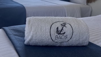 A hotel room with a bed, a window with a view, and a towel with a logo.
