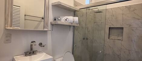 Un baño moderno con inodoro, lavabo y ducha.