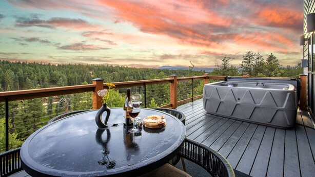 A deck with a round table, a bottle of wine, and a glass on it. - Mountain & Pond Views, Hot Tub, Stargazing, Kid + Dog Friendly, Loft+3BR (Florissant)