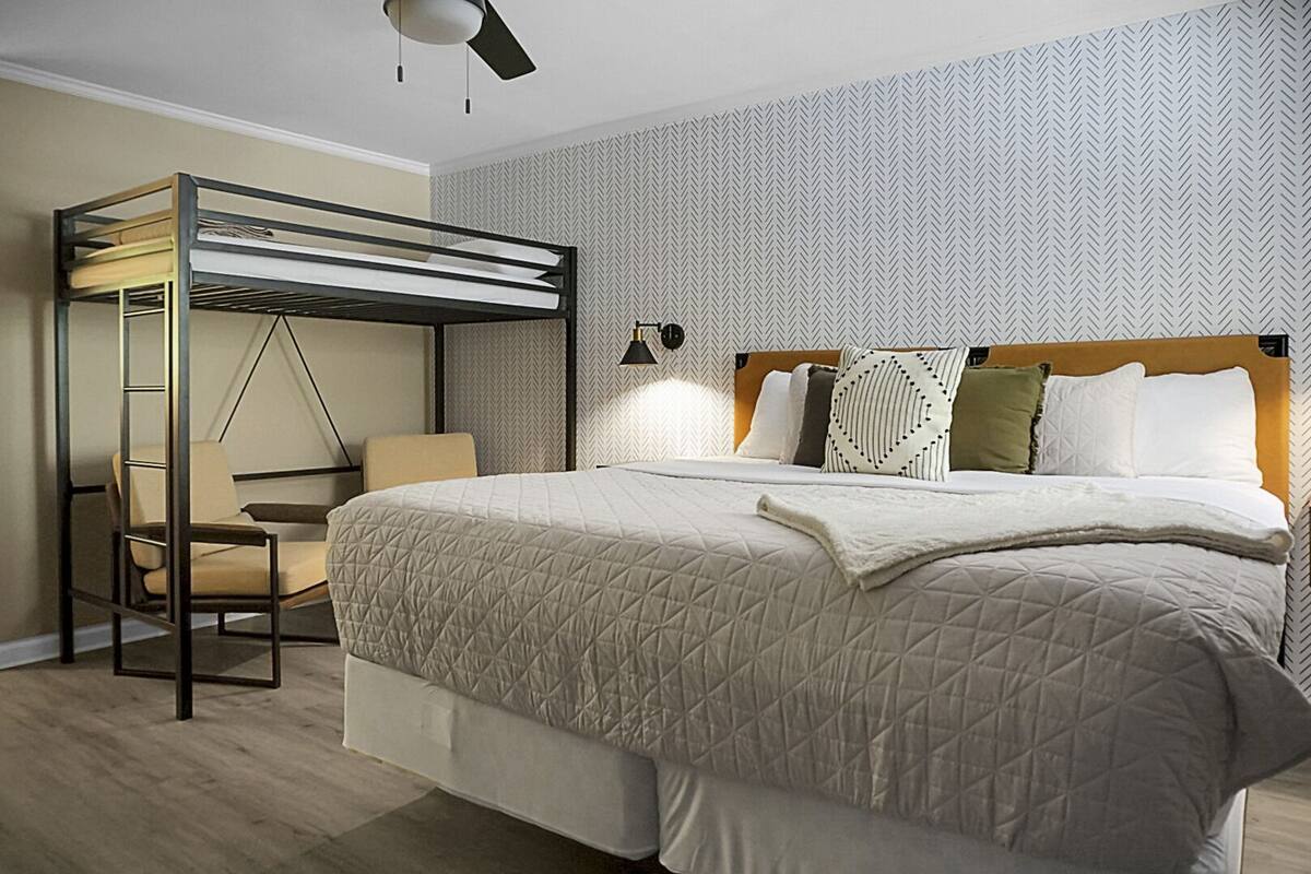 Ein modernes Schlafzimmer mit einem Etagenbett, einem Sessel und einem Nachttisch.