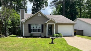 A residential house with a front yard, a driveway, and a garage.