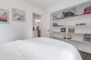 A bedroom with a large bed, a white wardrobe with shelves, and two framed pictures on the wall. - CU at Copper Creek for a memorable 5 star experience.  (Benton)
