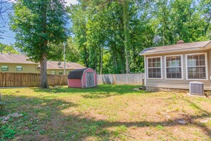 A residential backyard with a wooden fence, a shed, and a house with a windowed porch. - CU at Copper Creek for a memorable 5 star experience.  (Benton)