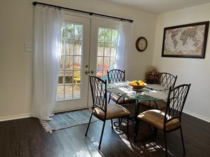 A dining area with a glass table, four chairs, a bowl of fruit, and a world map on the wall. - CU at Copper Creek for a memorable 5 star experience.  (Benton)