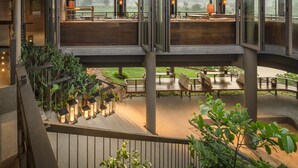 Una terraza al aire libre con varios niveles, espacios de estar y faroles, rodeada de vegetación.