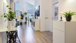 A modern kitchen with white cabinetry, a dining area with a white table and chairs, and a hallway with a wooden floor. - Idyllic Holiday Home with Private Terrace and Wi-Fi (Edewecht)