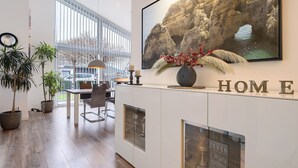 A modern interior with a dining area, large windows, a mounted painting, and a 'HOME' sign. - Idyllic Holiday Home with Private Terrace and Wi-Fi (Edewecht)