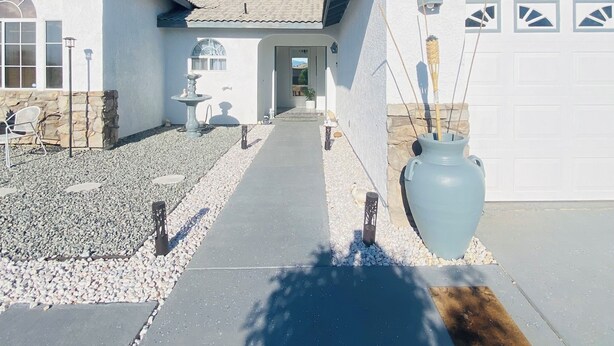 A residential property with a paved driveway leading to a garage, a stone pathway, and a decorative light fixture. - mounting view and popular for hiking area (Desert Hot Springs)