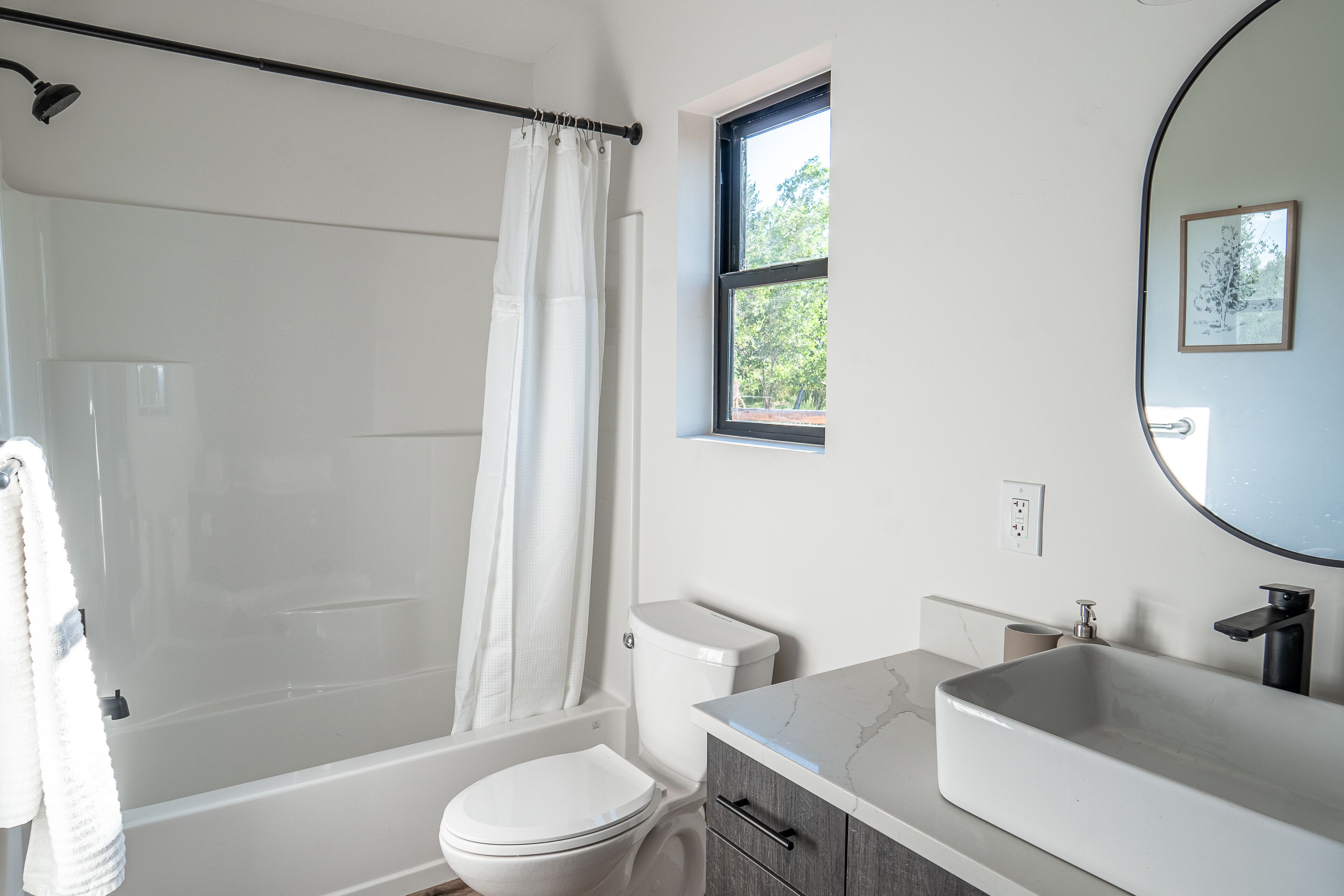 A bathroom with a bathtub, toilet, and sink.