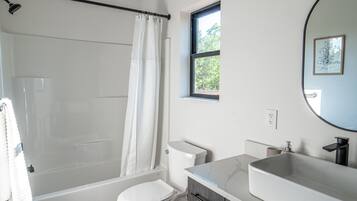 A bathroom with a bathtub, toilet, and sink.