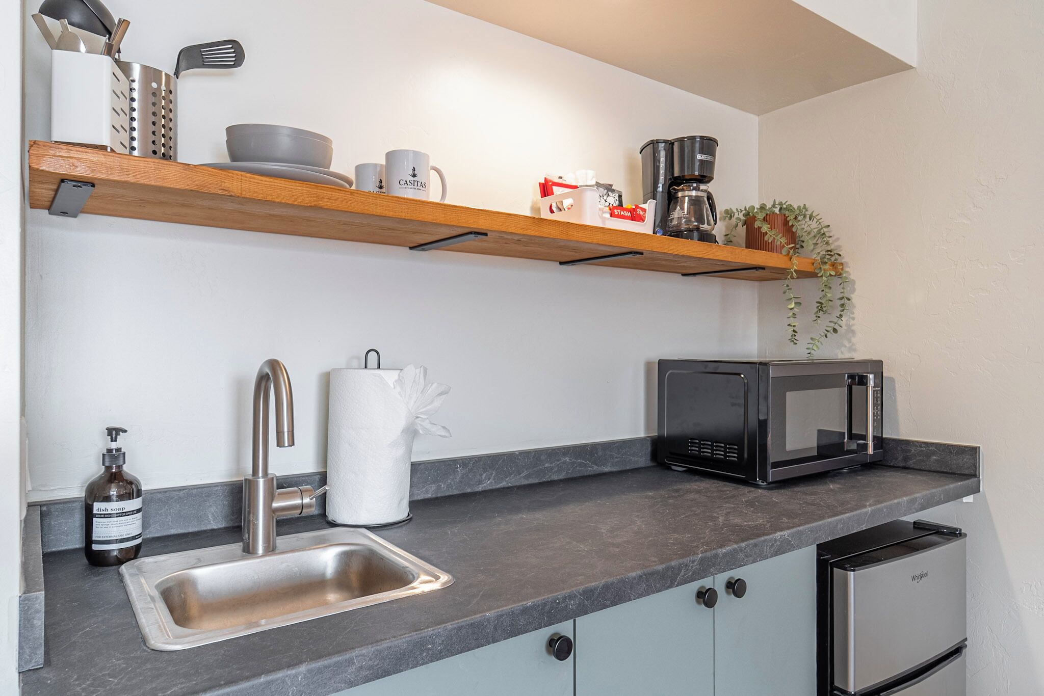 A modern kitchen with a stainless steel sink, a microwave, and a built-in oven.
