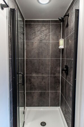 Comfort huis | Badkamer | Een douche, een haardroger, handdoeken, zeep