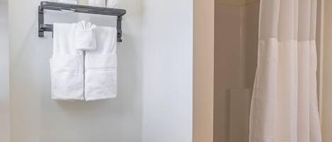 Een badkamer met toilet, douchegordijn, wastafel en prullenbak.