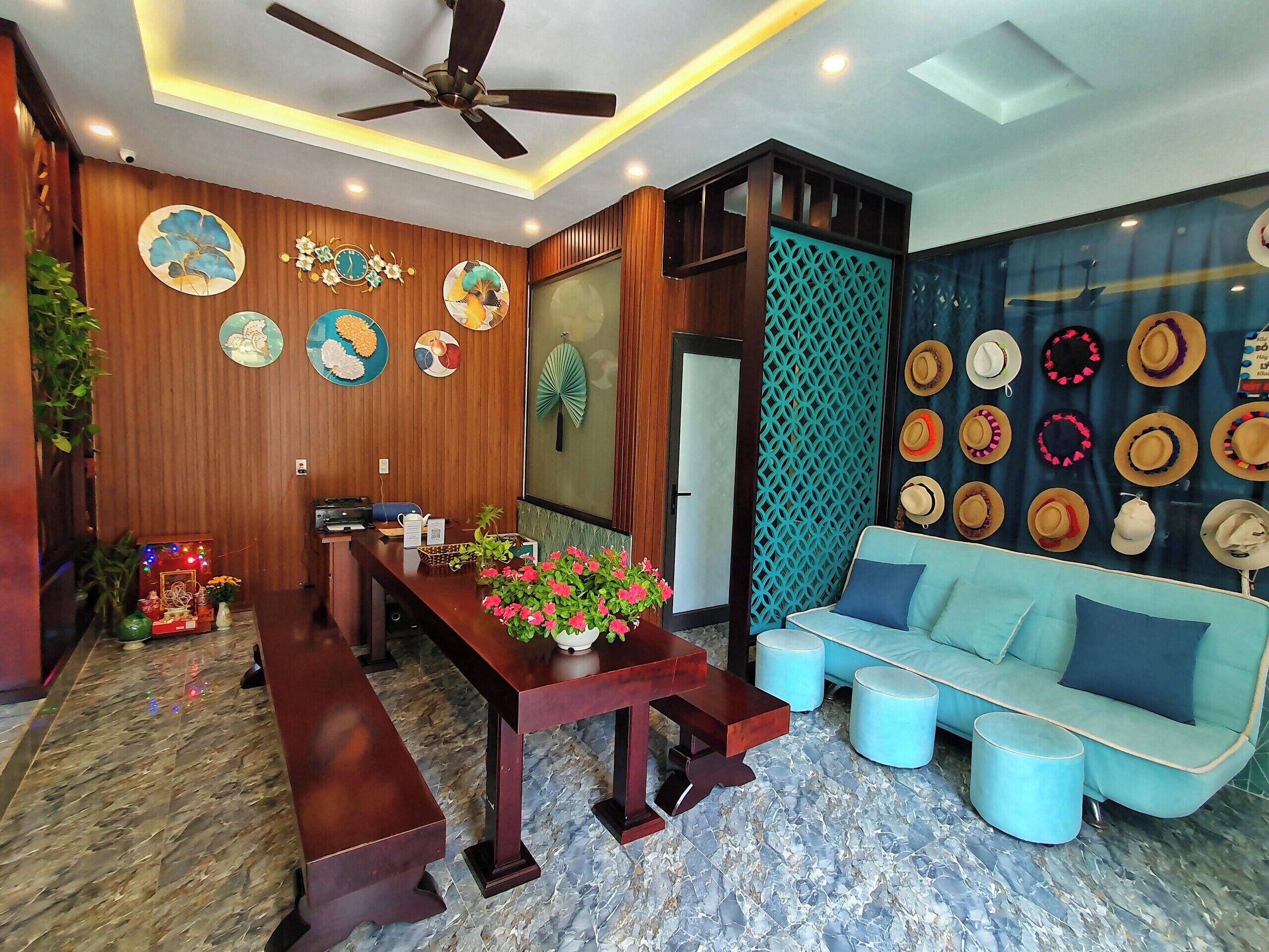A modern living room with a wooden wall, a ceiling fan, a sofa, and a coffee table.
