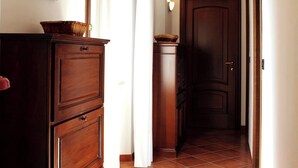 A hallway with wooden cabinets, a door, and a tiled floor. - La Culla Tra I Vigneti - Stanza (Grazzano Badoglio)