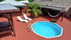 A swimming pool with lounge chairs and a wooden deck.