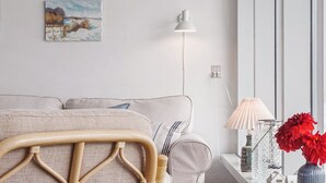 A modern room with a sofa, a lamp, a vase with flowers, and a painting on the wall. - "Werna" - 900m from the sea by Interhome (Pandrup)