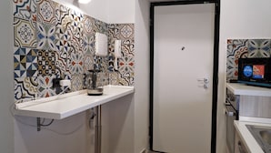 Una cocina con encimera blanca, máquina de café, microondas y salpicadero decorado.