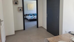 A modern hotel room with a bed, a dark door, and a small table with glasses. - Peaceful cottage with spa and air conditioning in Couzon (Couzon)