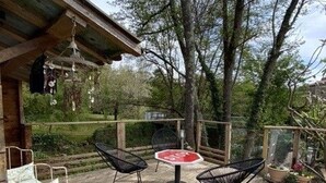 An outdoor deck with two black chairs, a small table, and a hanging light fixture. - Renovated House with Shared Pool and Garden in Mareuil-sur-Lay, Sleeps 6 (Mareuil-sur-Lay-Dissais)