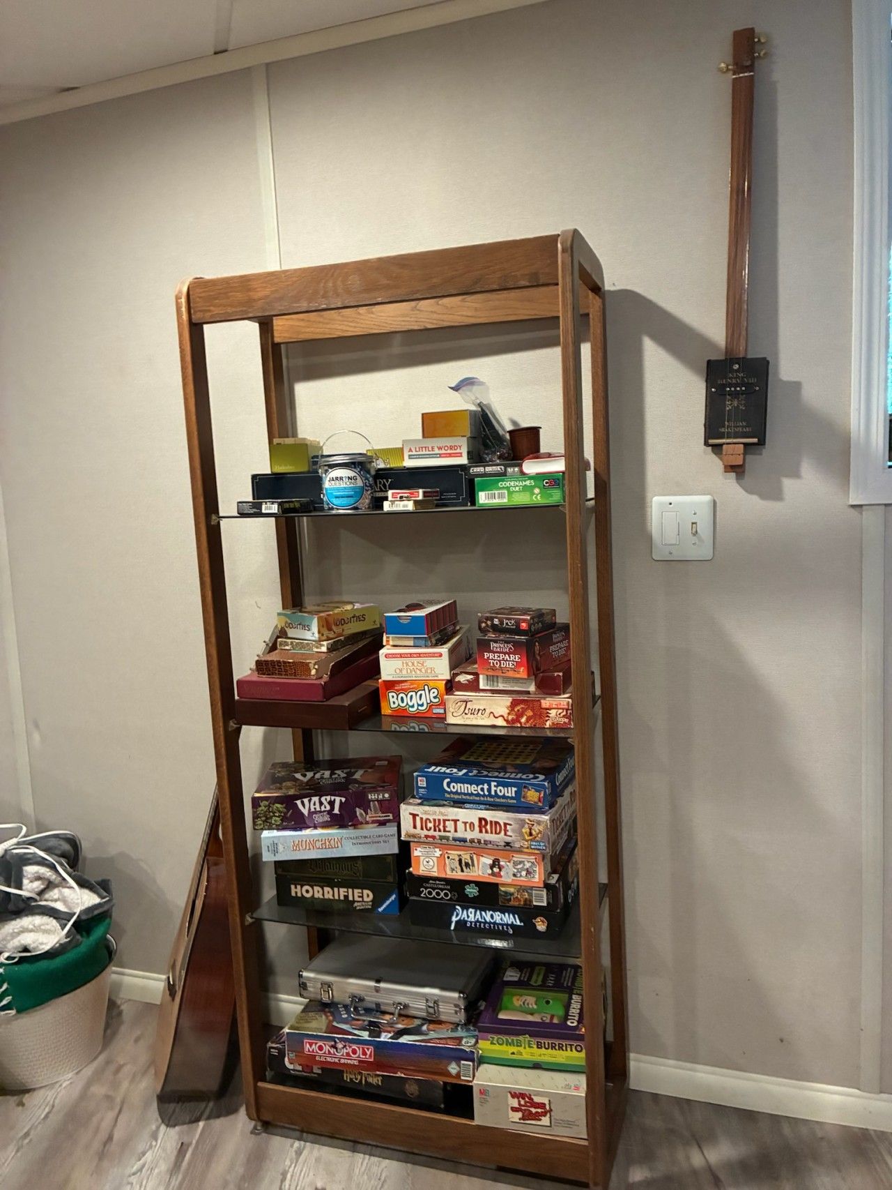 Une bibliothèque en bois remplie de différents jeux de société.