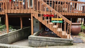 A wooden staircase leading to a building with a gym, community area, and bathroom/shower.
