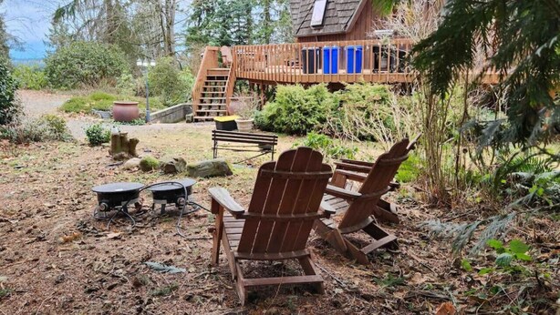Una cabaña rústica con terraza de madera, rodeada de un paisaje natural.