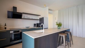 A modern kitchen with a central island, dark cabinetry, and a coffee machine. - Cozy home in Otok Babac with private swimming pool, can be inside or outside (Otok Babac)