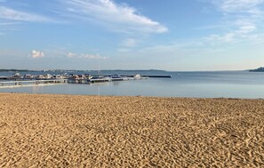 Une plage de sable où des bateaux sont amarrés à un quai.
