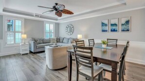 Un salón espacioso con una gran mesa de comedor, un sofá y un ventilador de techo.