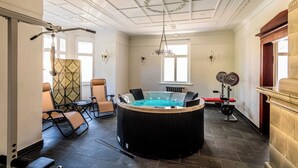 A room with a hot tub, exercise equipment, and seating. - Villa Hänsch (Grossschoenau)