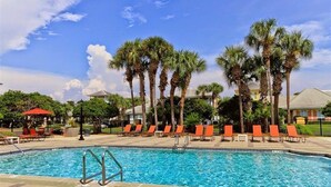 A swimming pool with lounge chairs and palm trees. - Remodeled home minutes to the beach! (Miramar Beach)