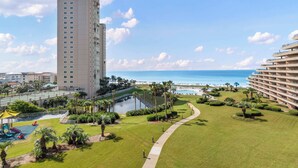 A high-rise hotel with a pool, a golf course, and a view of the ocean. - Updated beach condo with stunning views! (Miramar Beach)