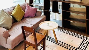 Uma sala de estar moderna com sofá, televisão e uma mesinha.